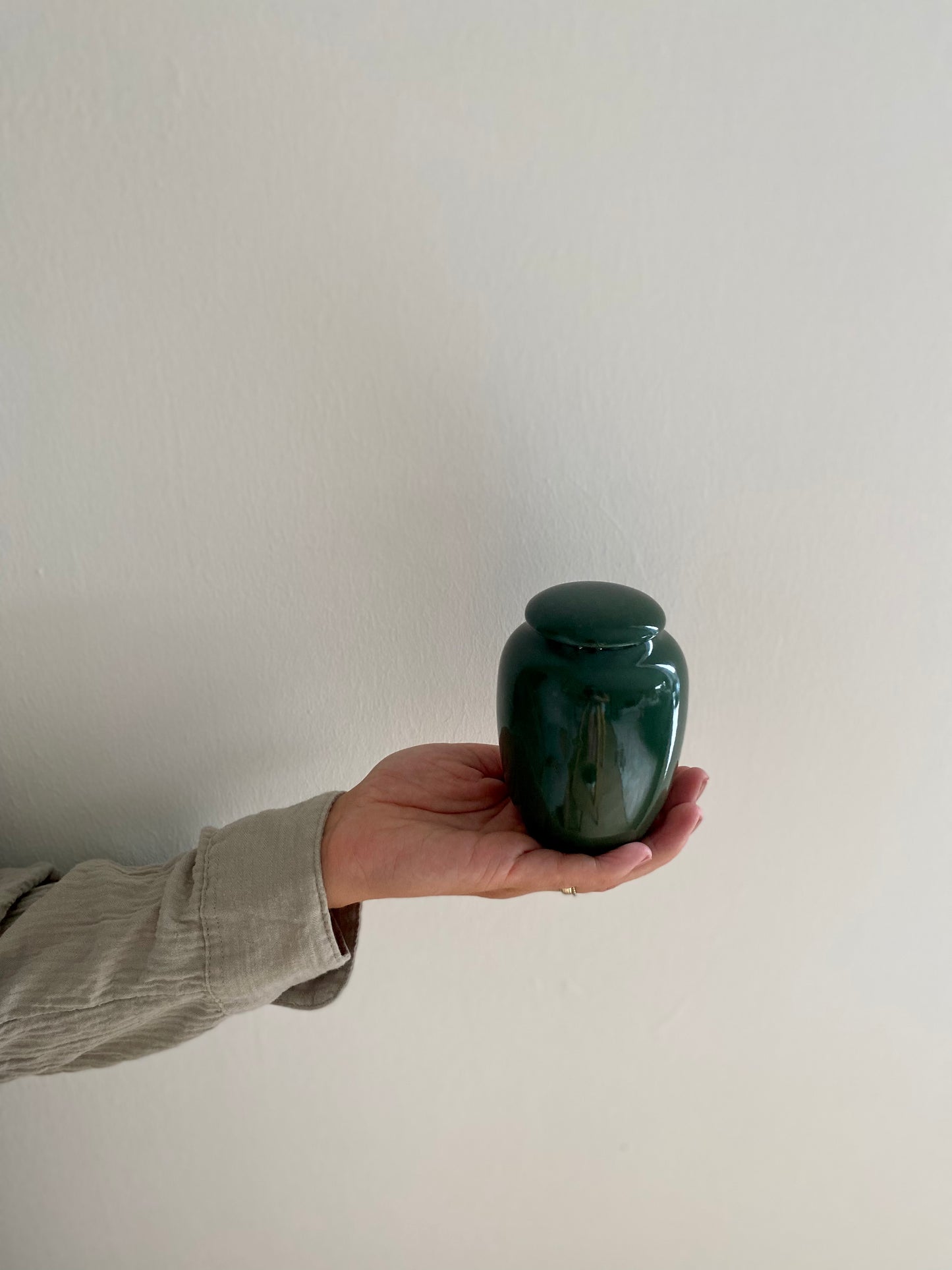 kleine mini groene urn keramiek voor mens en dier in hand
