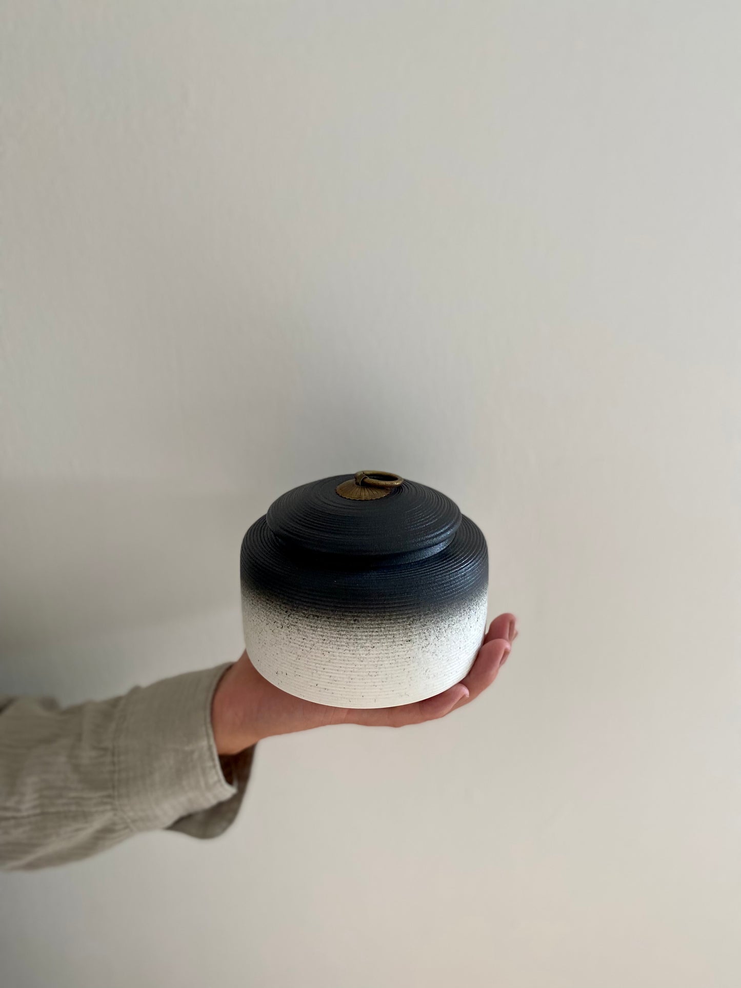 grote zwart witte oosterse urn voor mens en dier in hand