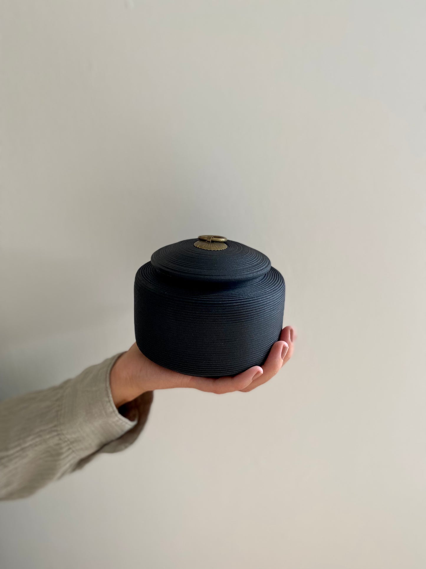 grote zwarte oosterse keramische urn voor mens en dier in hand