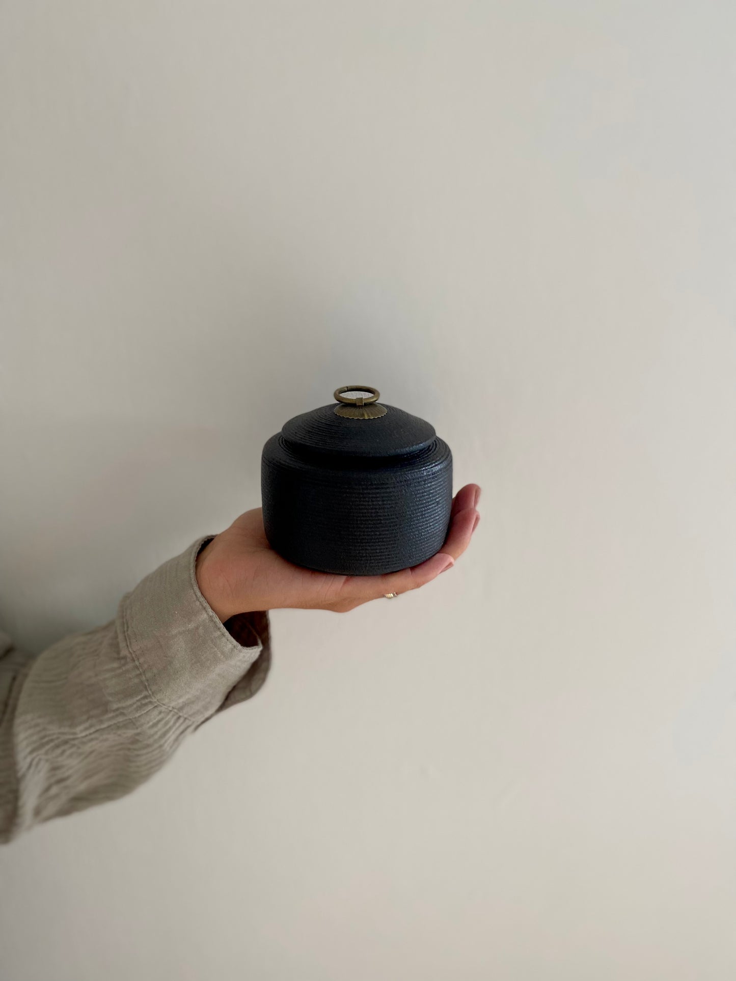kleine zwarte oosterse urn voor mens en dier in hand