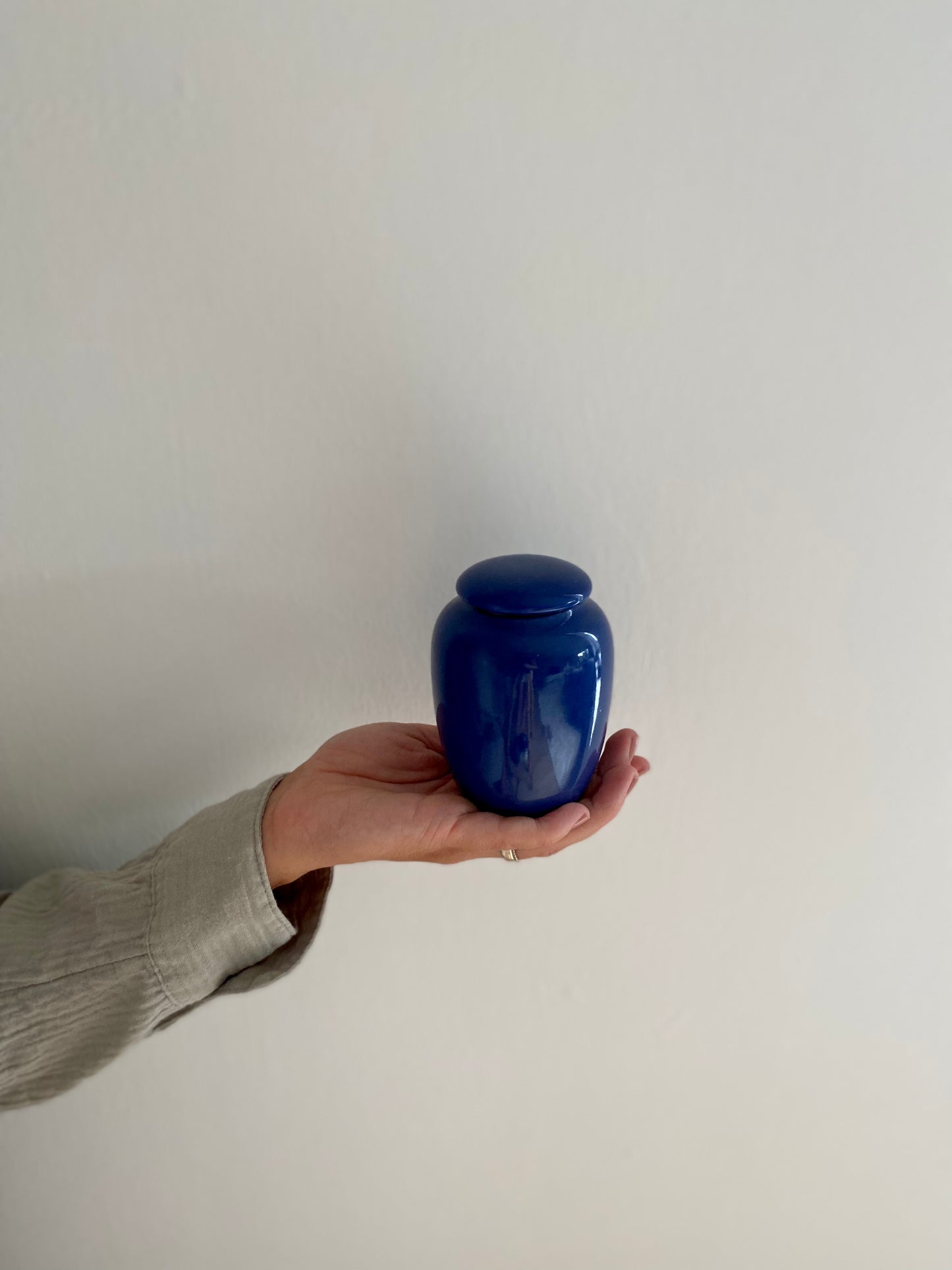kleine blauwe urn keramiek voor mens en dier in hand