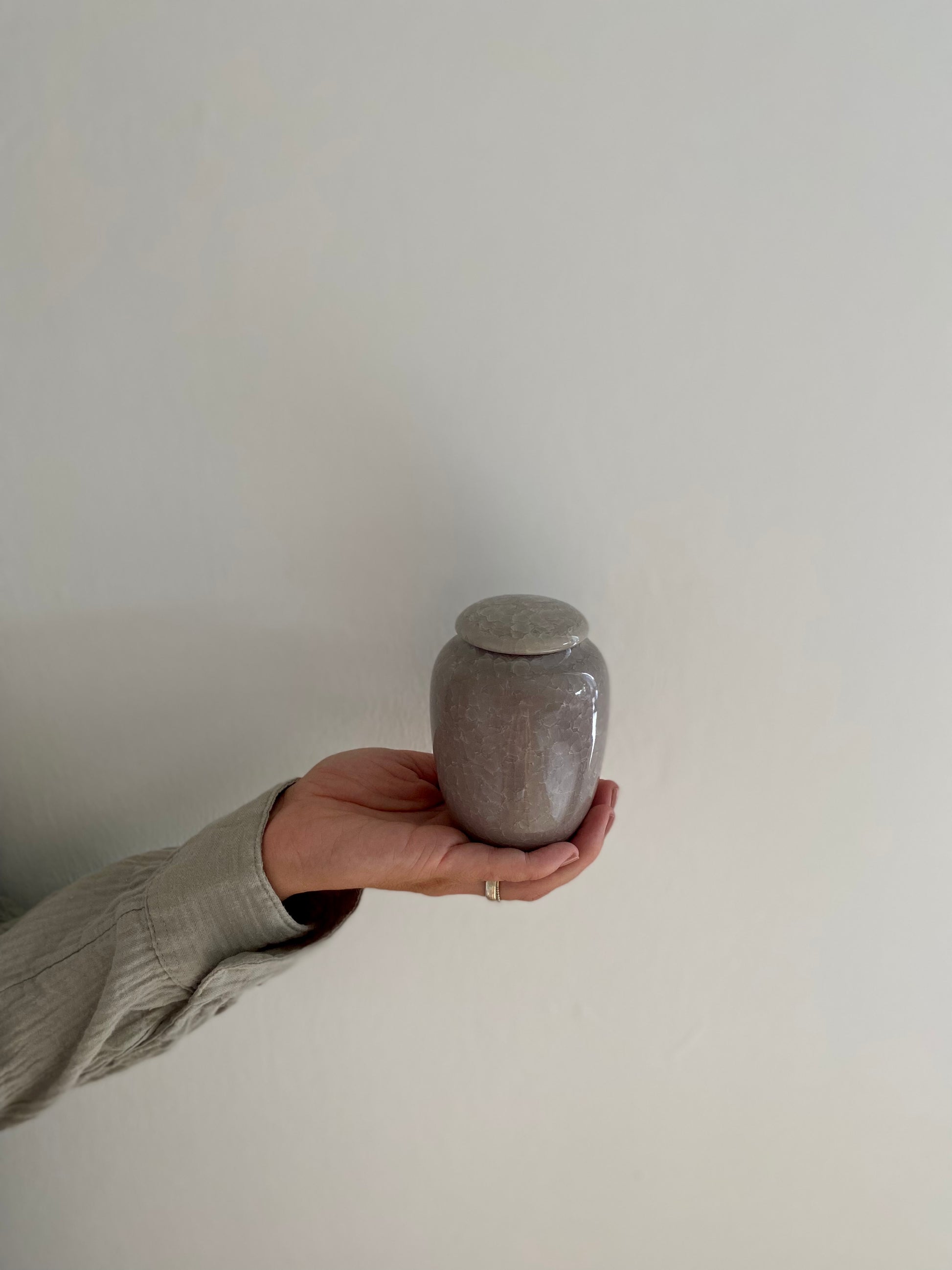 kleine zand kleur urn keramiek voor mens en dier in hand