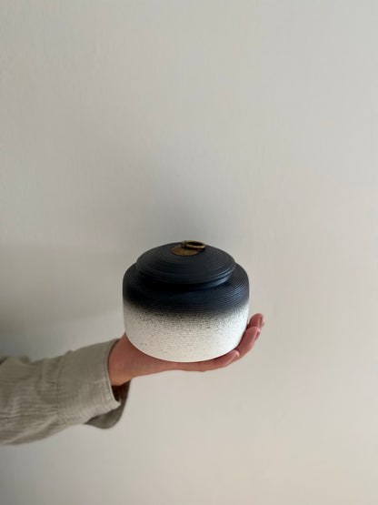 grote zwart witte oosterse urn voor mens en dier in hand