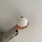 kleine witte oosterse keramische urn voor mens en dier in hand